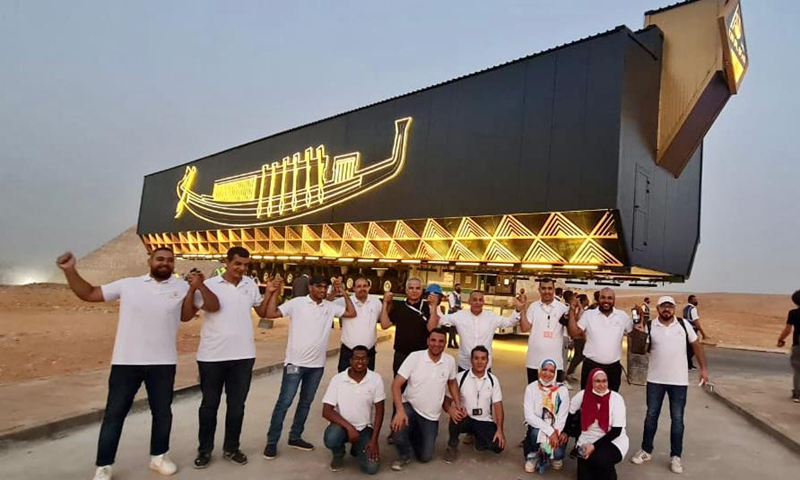 Staff members escort the first Khufu solar boat, carried by a specialized large vehicle, to the Grand Egyptian Museum at the Giza Pyramids scenic spot in Giza, Egypt, Aug. 6, 2021.(Photo: Xinhua)