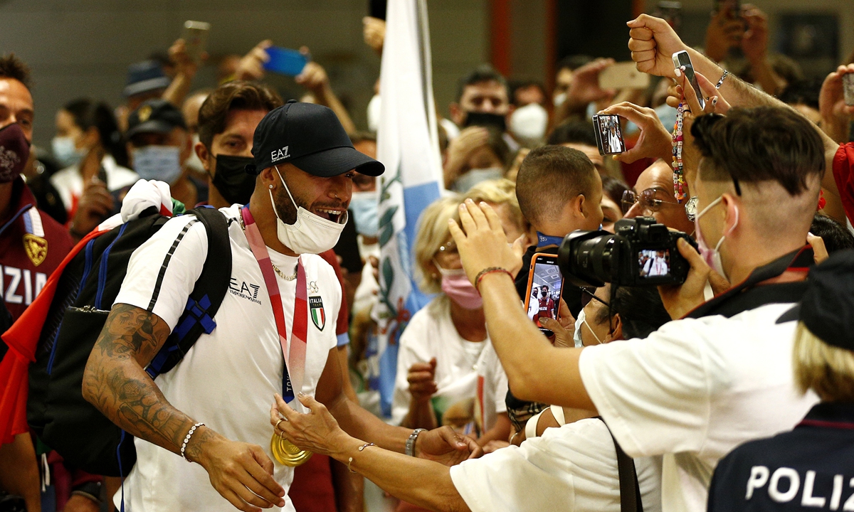 Italy's 100m gold medal winner Lamont Marcell Jacobs cheers with friends and relatives as he arrives from the 2020 Tokyo Olympics at Rome's Fiumicino Airport on August 9, 2021. Photo: AFP