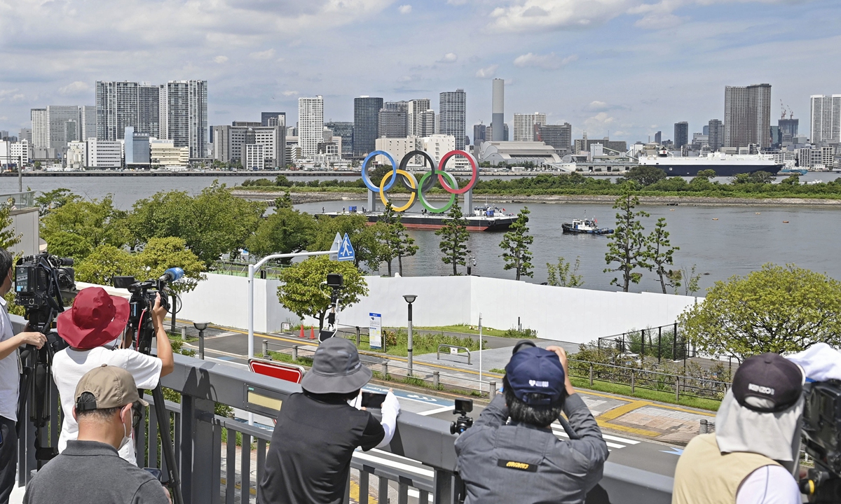 Local media take footage of the removal of the Olympic rings monument in Tokyo's Odaiba waterfront area on Wednesday, three days after the closing ceremony of the Tokyo Olympics. It will be replaced with a symbol of the Paralympics, which is scheduled to be held from August 24 to September 5. Photo: AFP
