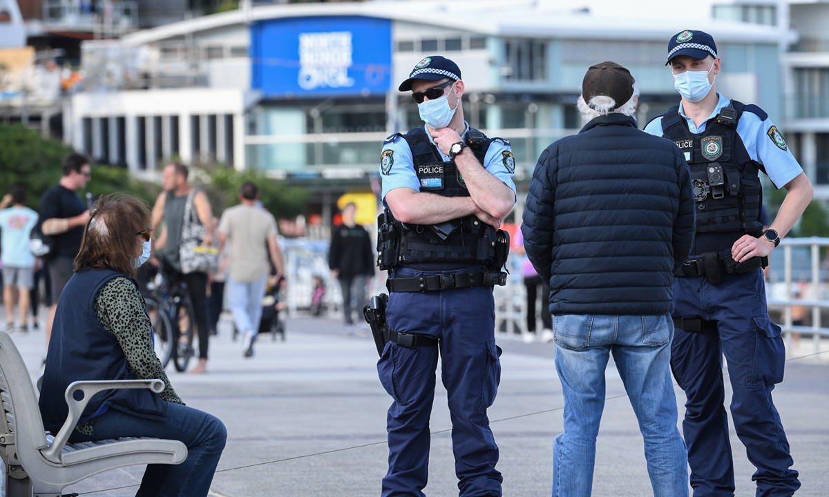 New South Wales police officers talk to locals on the beach promenade on Tuesday in Sydney, Australia. Photo: VCG