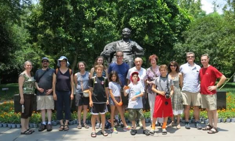 Ezra Vogel and his family taking a photo with Deng Xiaoping's statue
