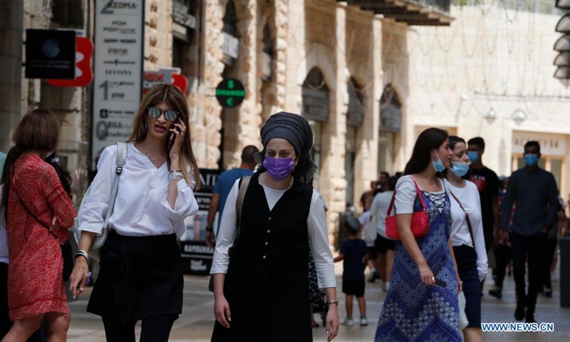 People wearing face masks walk on a street amid the COVID-19 pandemic in Jerusalem, on Aug. 11, 2021. (Photo by Muammar Awad/Xinhua)
