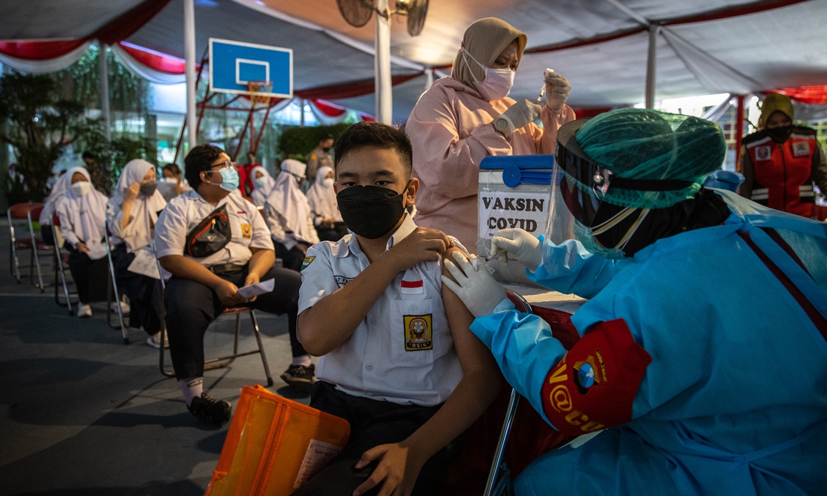 An Indonesian junior high school student is injected with the Sinovac vaccine on Thursday in Surabaya. Indonesia has recorded over 100,000 deaths from COVID-19 as the country continues to struggle with a huge wave of infections driven by the Delta variant.Photo: VCG