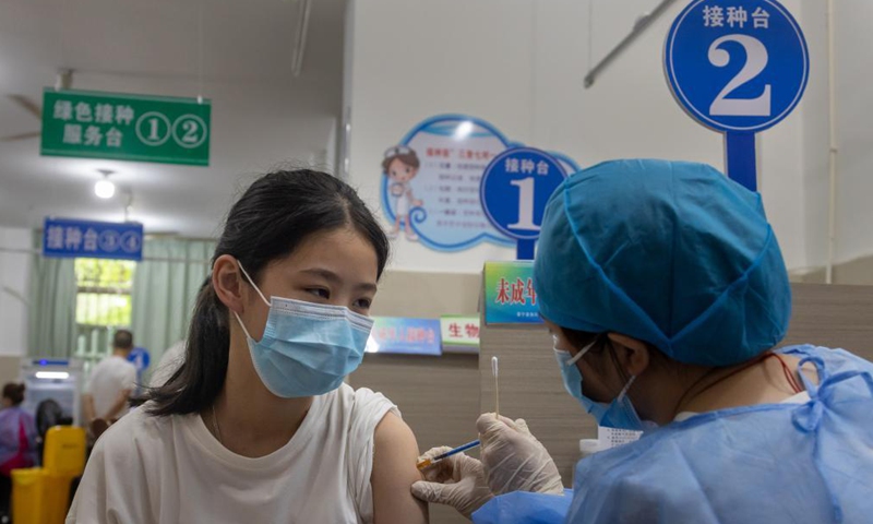 A girl receives a dose of COVID-19 vaccine at a vaccination point in Jingning She Autonomous County in Lishui, east China's Zhejiang Province, Aug. 12, 2021.Photo:Xinhua