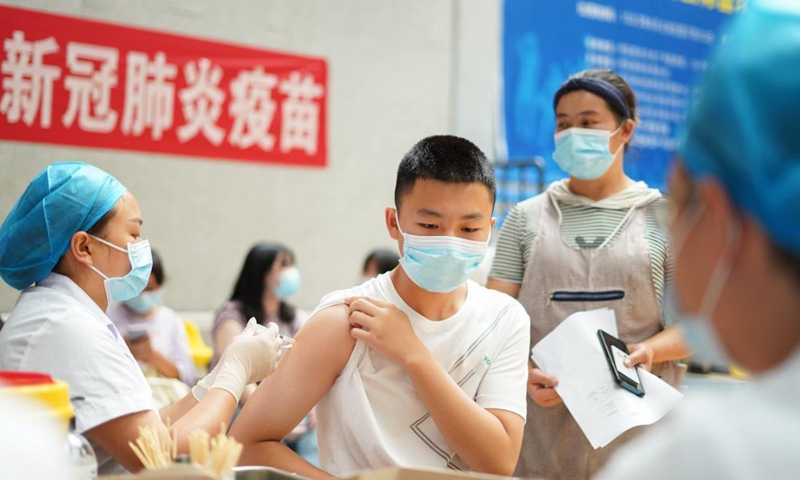 A student receives a dose of COVID-19 vaccine at a vaccination point in Danzhai County, southwest China's Guizhou Province, Aug. 12, 2021. China is orderly propelling its vaccination program among minors aged between 12 and 17, on the premise of ensuring safety.Photo:Xinhua