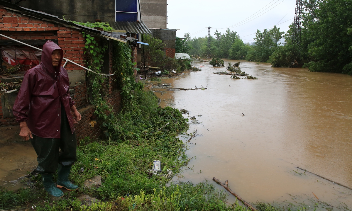 A man looks at floods on Friday in Xiangyang, Central China's Hubei Province after a record downpour  inundated parts of the province. Photo: VCG