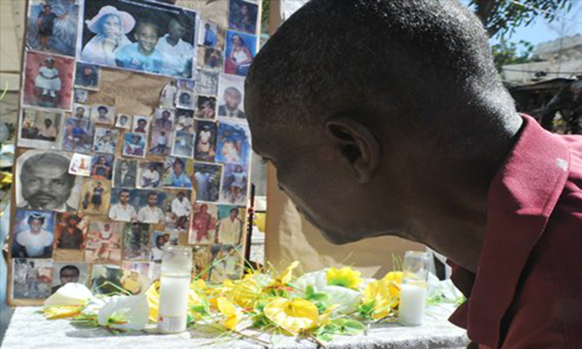 A man pays his respects at a makeshift memorial for victims of the January 12, 2010 Haiti earthquake near the destroyed Cathedral of Port-au-Prince on Saturday. Photo: AFP  