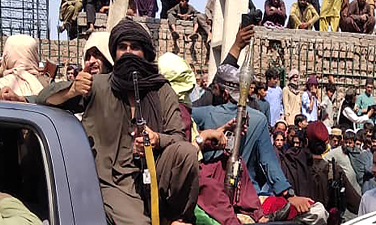 Taliban fighters sit on a vehicle along the street in Jalalabad province on Sunday. Photo: AFP