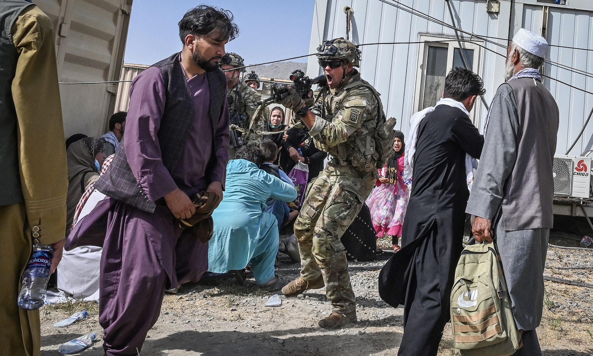 A US soldier (center) points his gun at an Afghan passenger at Kabul airport on Monday as thousands of people mobbed the city's airport trying to flee the country. Photo: AFP