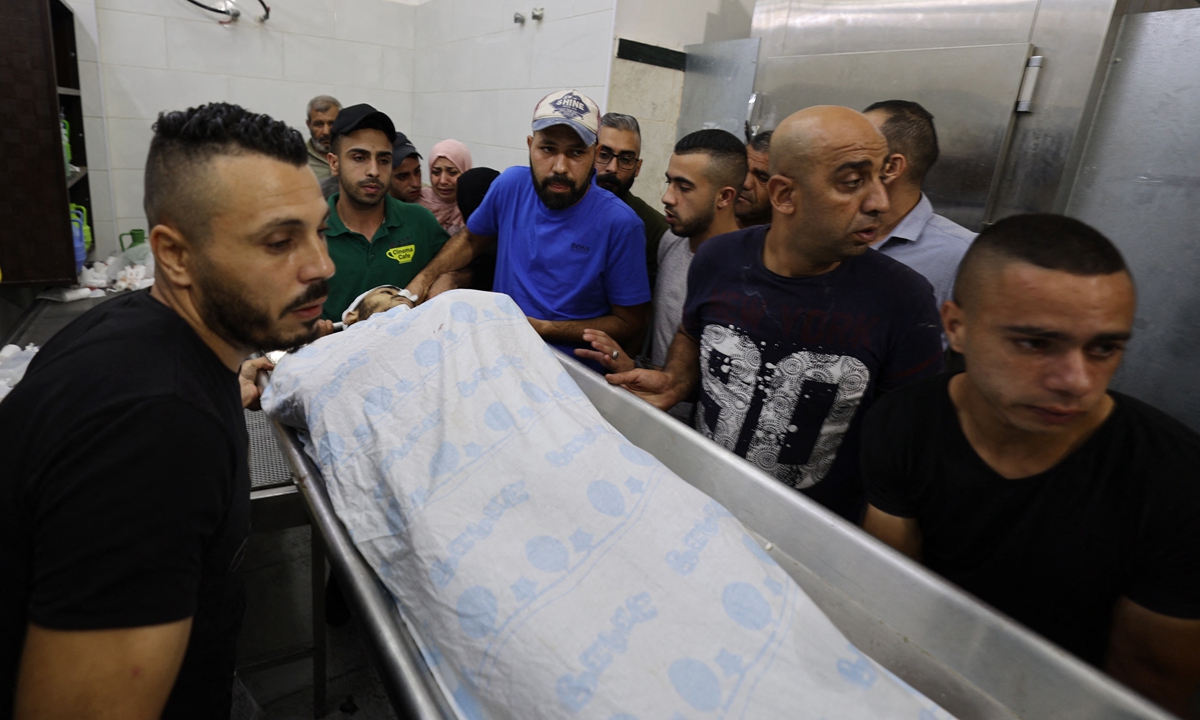 Friends and relatives carry the body of Palestinian Raed Abu Seif killed in clashes with Israeli security forces in the Jenin refugee camp in the north of the occupied West Bank, at the Jenin hospital morgue on Monday. At least four Palestinians were killed in the clashes, an Israeli official and the Palestinian health ministry said. Photo: AFP