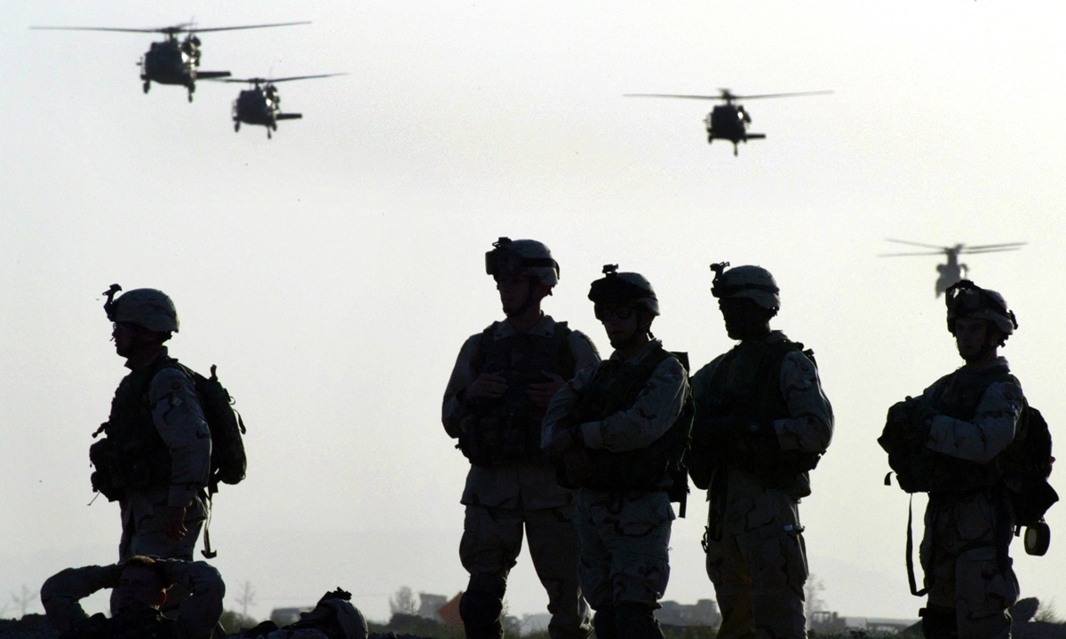 American soldiers wait to board helicopters at Kandahar airbase ahead of an operation in Afghanistan on 19 May, 2003. Photo: AFP