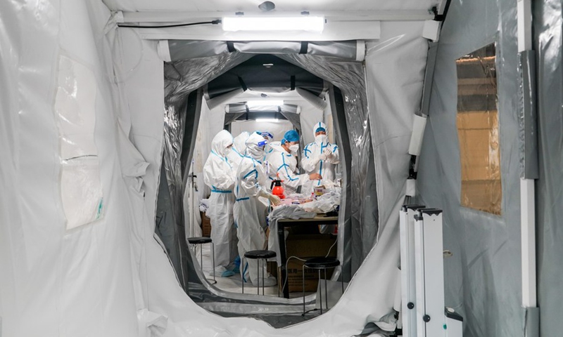 Medical workers put on protective suits at a Falcon air-inflated testing lab for COVID-19 nucleic acid testing at Yangzhou International Exhibition Center in Yangzhou, east China's Jiangsu Province, Aug. 14, 2021.(Photo: Xinhua)