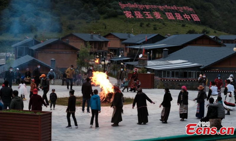 黄昏时分，在中国西南部西藏自治区山南市玉麦乡，村民们聚集在一起跳藏族传统篝火舞果庄。  （图：中新社/蒋飞波）