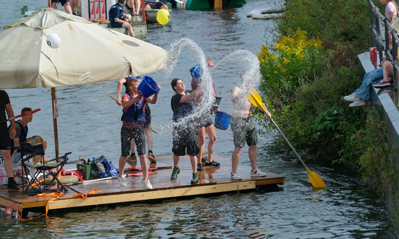 Participants interact with the audience during the International Bathtub Regatta on the Meuse River in Dinant, Belgium, on Aug. 15, 2021.(Photo: Xinhua)
