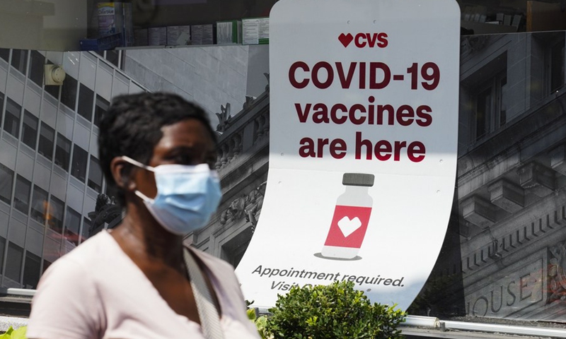 A woman walks past a sign of COVID-19 vaccination at a pharmacy in New York, the United States, Aug. 11, 2021. (Xinhua/Wang Ying)