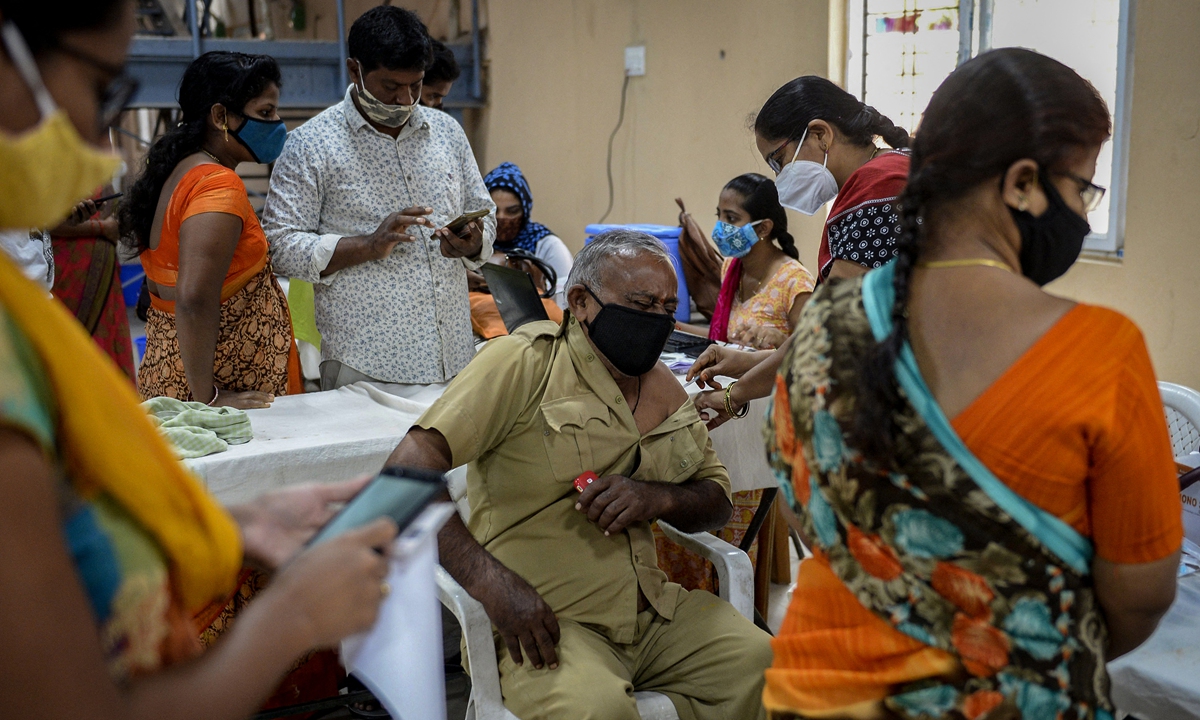 A health worker inoculates a man (center) with the dose of Covishield vaccine against COVID-19 at a vaccination center on the outskirts of Hyderabad, India on Tuesday. India has reported 32.2 million infections as of Tuesday, with about 432,000 deaths. Photo: AFP