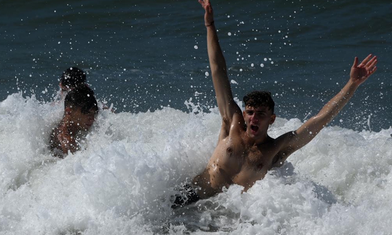 People spend time in the sea off Ladispoli in Lazio, Italy, on Aug. 17, 2021. (Photo by Alberto Lingria/Xinhua) 