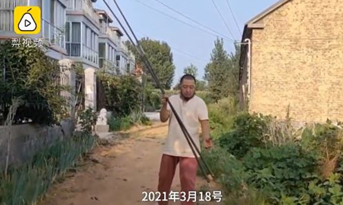 A 50-year-old man in East China's Shandong Province picks up an egg with a 4.6-meter giant iron chopsticks. Photo: Screenshot of a video posted by Pear Video