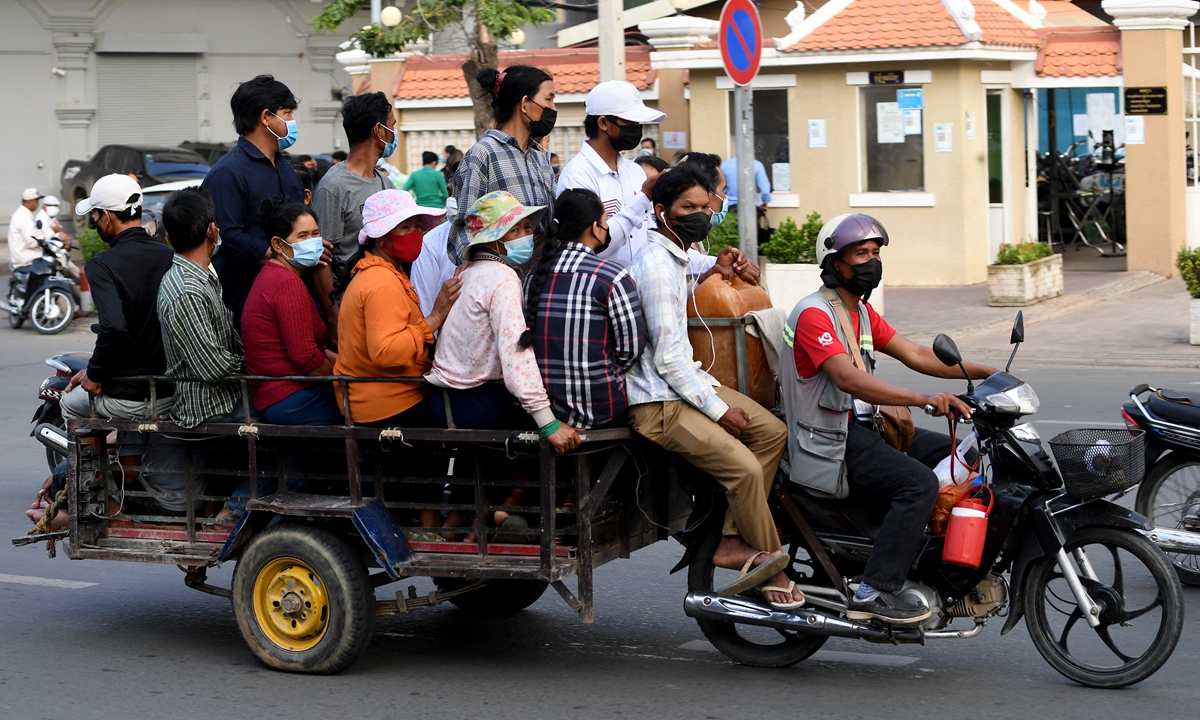 People sit on a cart pulled by a motorbike traveling along a street in Phnom Penh, Cambodia on Wednesday. Photo: AFP