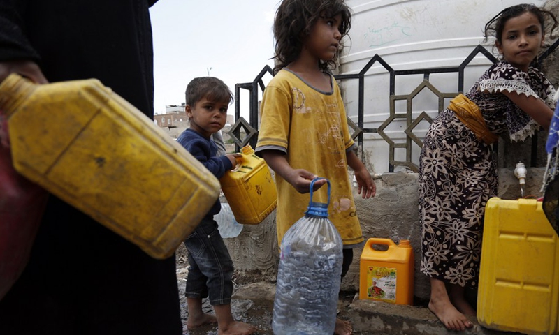 Children carry empty bottles waiting to fill them with clean water from a tap provided by a charity group in Sanaa, Yemen, on Aug. 17, 2021.(Photo: Xinhua)
