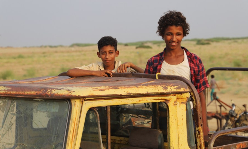 Two boys stand on a truck outside a relief center in Hajjah Province, north Yemen, waiting for their turn to collect the charity food ration on Aug. 15, 2021.(Photo: Xinhua)