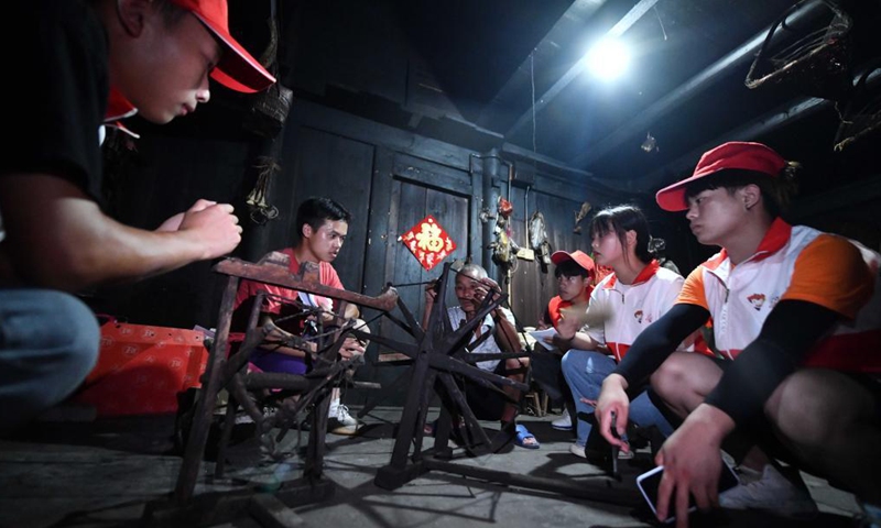 Students collect old farm tools at Wuying Village, which lies on the border between south China's Guangxi Zhuang Autonomous Region and southwest China's Guizhou Province, on Aug. 20, 2021. In the summer of 2021, a volunteer team consisted of college and middle school students led local pupils to participate in diverse activities, such as maintaining saplings, learning about intangible cultural heritages and collecting old farm tools for museums. (Xinhua/Huang Xiaobang)