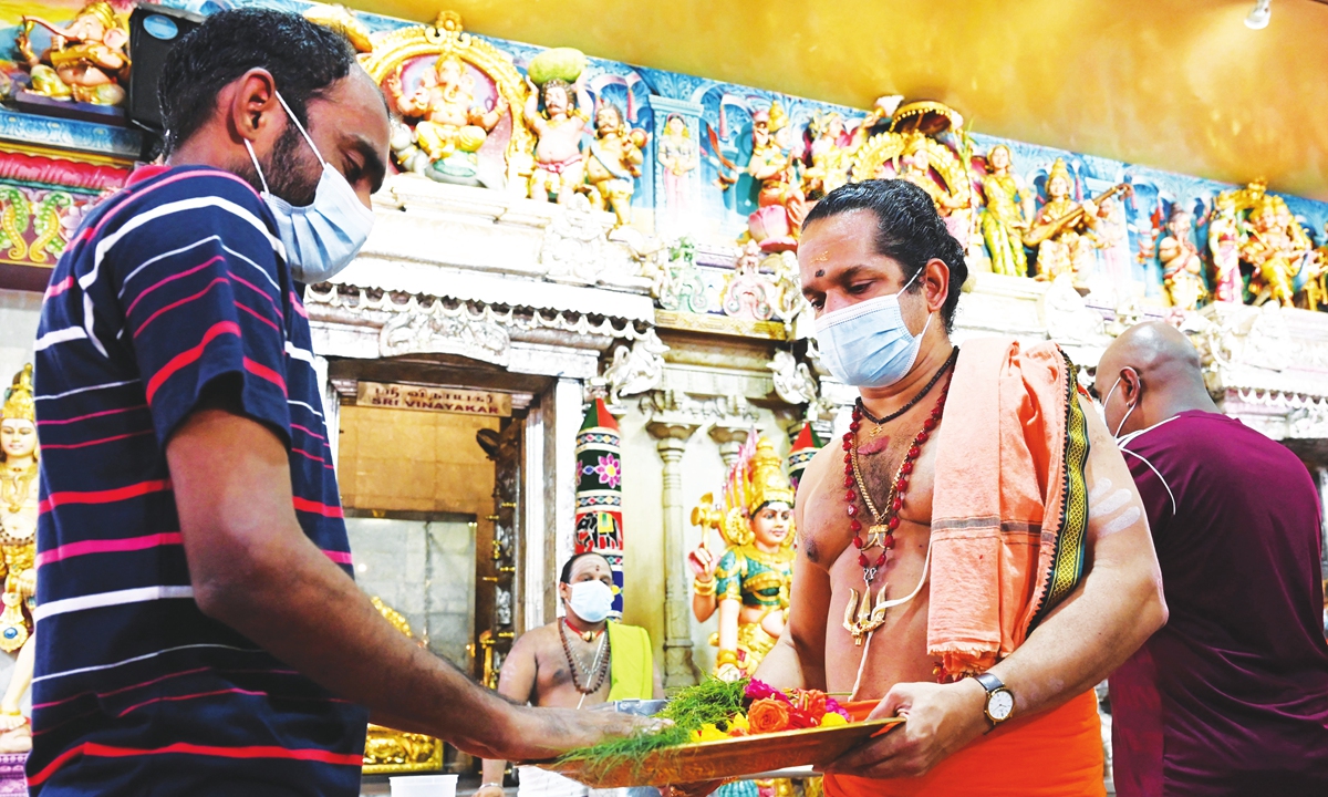 A migrant worker receives a blessing from a Hindu priest during a visit to the Sri Veeramakaliamman temple in the district of Little India, Singapore on Wednesday. Photo: AFP
