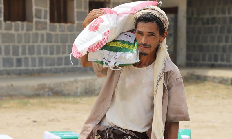 A man carries a bag of charity food in a relief center in Hajjah Province, north Yemen, on Aug. 15, 2021.(Photo: Xinhua)