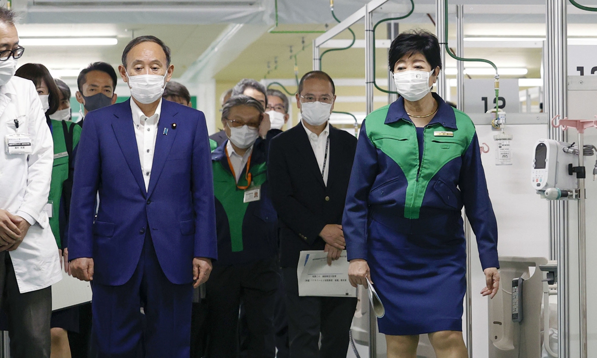 Japanese Prime Minister Yoshihide Suga, second from left, visits an 