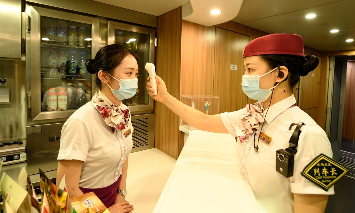 A staffer at the Chengdu railway station gets a temperature check on Thursday. The railway station still has strict health check and epidemic control measures to prevent the spread of coronavirus. The railway is expected to carry 750 million passengers during the summer peak, which ends on August 31. Photo: cnsphoto