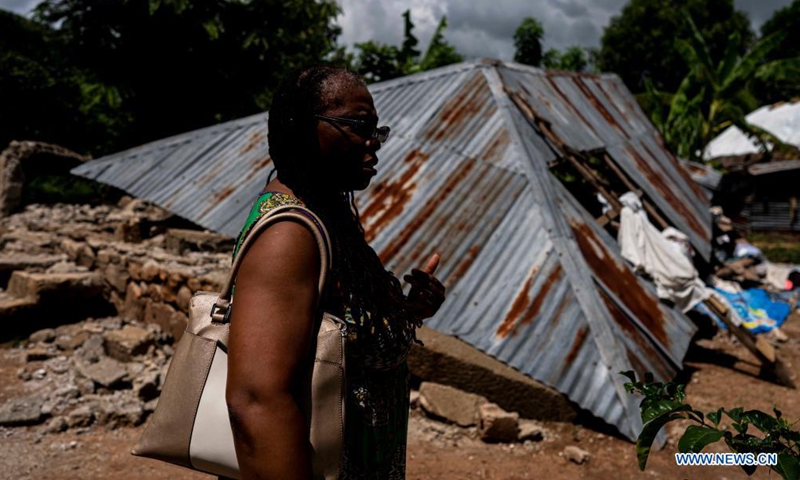 A woman walks in front of a damaged house in Lievre, Nippes, Haiti, on Aug. 19, 2021. The death toll from a powerful earthquake that struck southwest Haiti on Saturday climbed to 2,189, the Caribbean island's Civil Protection Agency reported on Wednesday.Photo:Xinhua