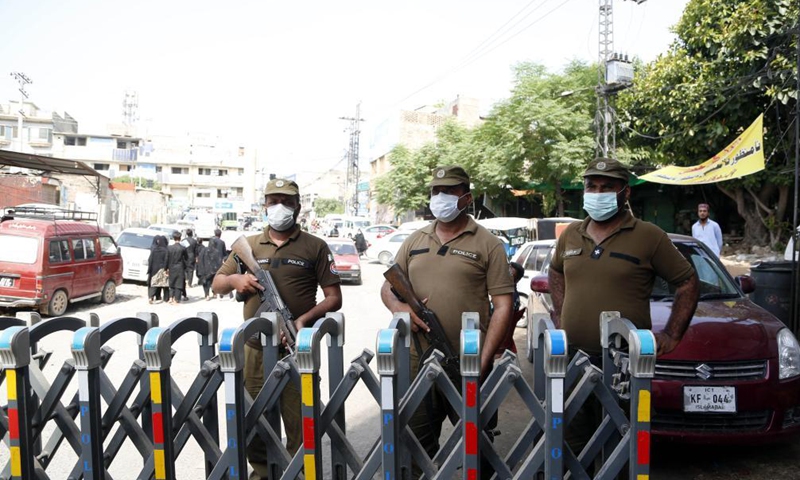 Policemen stand guard near a procession of Shia Muslims due to security high alert following an explosion, in Rawalpindi of Pakistan's Punjab province on Aug. 19, 2021. At least five people were killed and over 30 others injured after a hand grenade hit a religious procession in Bahawalnagar district of Pakistan's Punjab province on Thursday, a government official said.Photo:Xinhua
