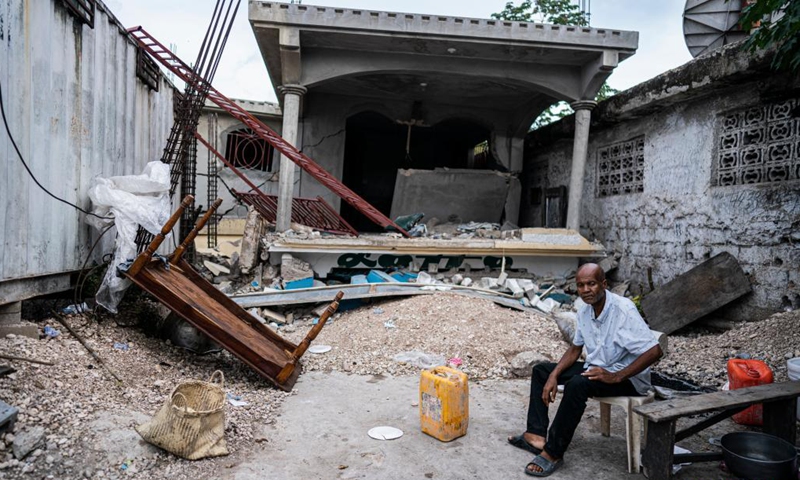 A man poses for a photo inside a damaged house in Aquin district, Sud, Haiti, on Aug. 19, 2021. The death toll from a powerful earthquake that struck southwest Haiti on Saturday climbed to 2,189, the Caribbean island's Civil Protection Agency reported on Wednesday.Photo:Xinhua