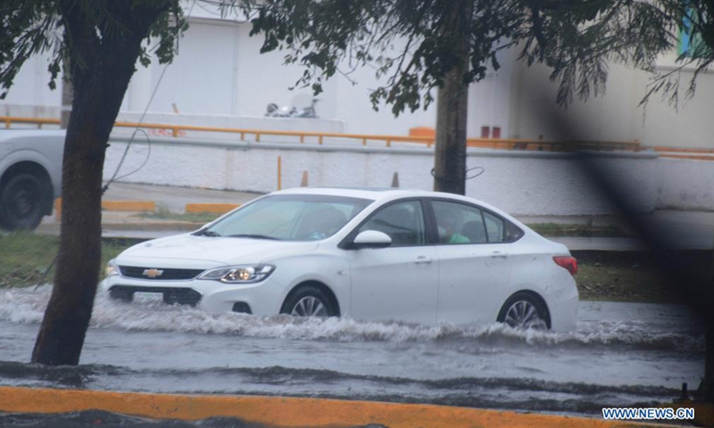 A car runs through a street flooded by the heavy rainfall due to the landfall of Hurricane Grace, in Cancun, Quintana Roo, Mexico, on Aug. 19, 2021.Photo:Xinhua