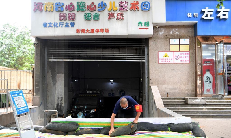 A man stacks sandbags at the entrance of an underground garage in Jinshui District of Zhengzhou, capital of central China's Henan Province, Aug. 22, 2021.Photo: Xinhua