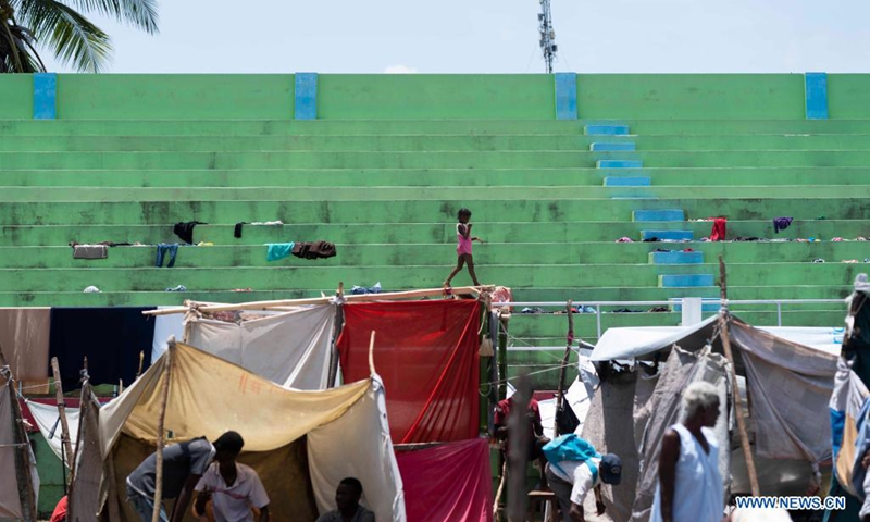 Photo taken on Aug. 21, 2021 shows a child walking in a stadium used temporarily as a shelter in Les Cayes, Haiti. (Photo: Xinhua)