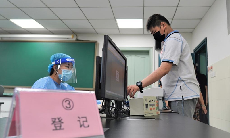 A student registers for vaccination at a vaccination point of Wenshu middle school in Nanjing, east China's Jiangsu Province, Aug. 23, 2021. Nanjing started administering the first dose of COVID-19 vaccines among minors aged between 12 and 17. (Photo by Ge Qingxin/Xinhua) 