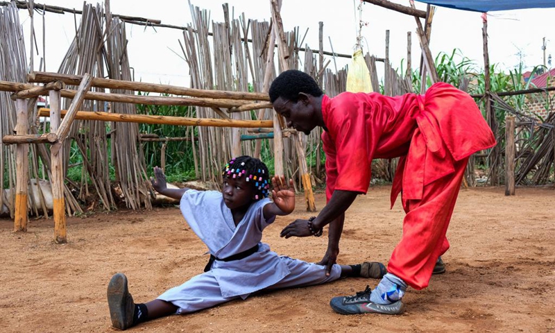 Manisuru Ssejjemba (R) instructs as his daughter Hasifa Nakirijja practices Chinese martial arts at a makeshift training center behind their house in Katooke, north of Uganda's capital Kampala, Aug. 17, 2021.Photo: Xinhua