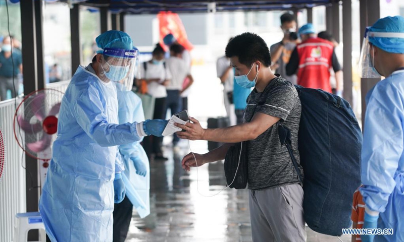 Staff members check a passenger's identity information and health code at Nanjing Railway Station in Nanjing, capital of east China's Jiangsu Province, Aug. 23, 2021. Nanjing, which witnessed the country's latest resurgence of coronavirus cluster infections attributable to the Delta variant, cleared all medium- and high-risk areas for COVID-19 on Aug. 19. From Aug. 23, people leaving Nanjing by rail, highway, waterway, etc. will no longer be required to provide negative nucleic acid test certificates. (Xinhua/Ji Chunpeng)