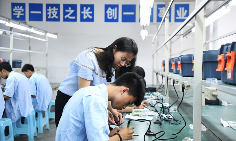 A teacher instructs as students practise electronic assembly at Nanchuan Longhua Vocational High School of Chongqing in southwest China's Chongqing File Photo: Xinhua