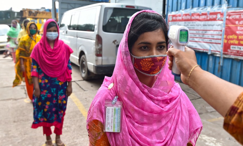 A worker has her body temperature checked at a garment factory in Dhaka, Bangladesh, on Aug. 23, 2021.(Photo: Xinhua)