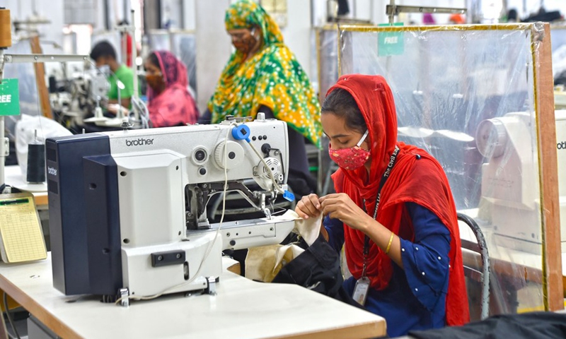 Photo taken on Aug. 23, 2021, shows sewing desks with plastic curtains installed to maintain social distancing for workers at a garment factory in Dhaka, Bangladesh.(Photo: Xinhua)