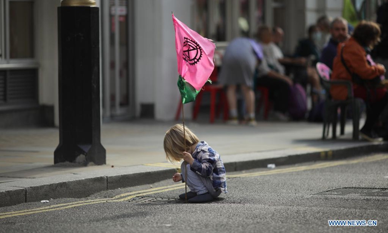 A young demonstrator takes part in the climate campaign group Extinction Rebellion protest near Leicester Square in London, Britain, on Aug. 23, 2021. (Photo by Tim Ireland/Xinhua)
