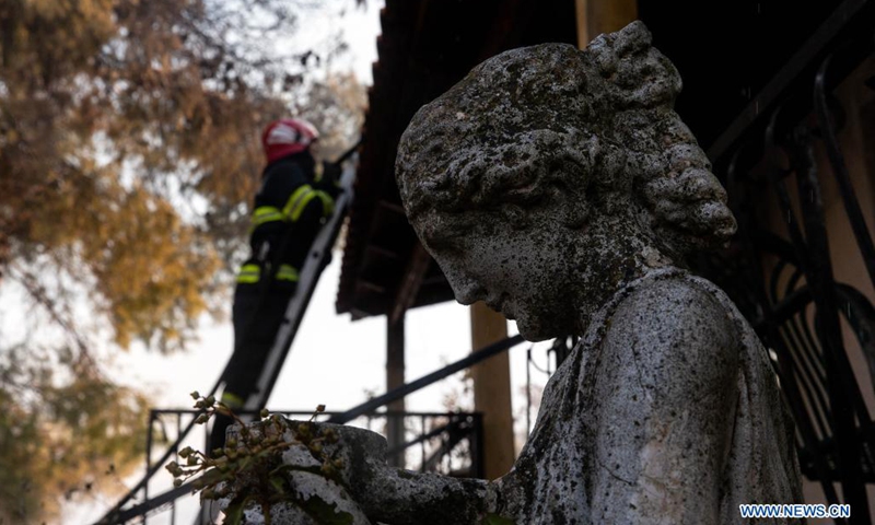 A statue is seen at a burned house as a firefighter battles a blaze in Vilia to the northwest of Athens, Greece, on Aug. 23, 2021. A new wildfire broke out here on Monday, burning in thick forest land.(Photo: Xinhua)
