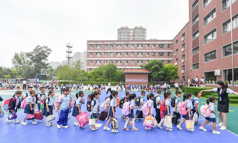 A teacher instructs as primary students enter a school building in Changchun, capital of northeast China's Jilin Province, Aug. 23, 2021. Primary and middle schools in Changchun greeted their new semesters on Monday. (Xinhua/Zhang Nan)


