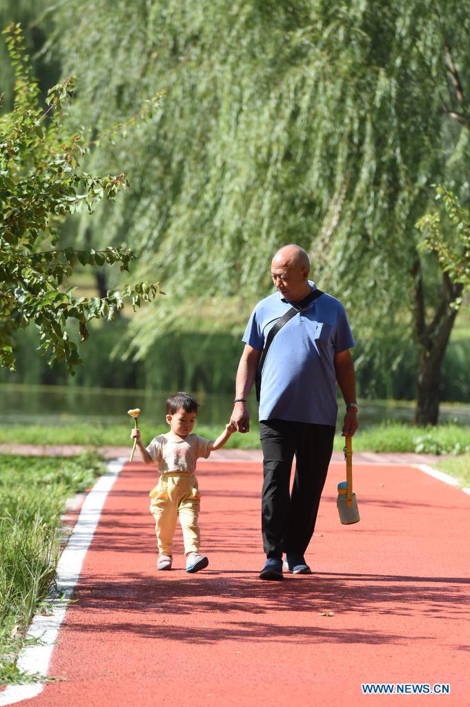 Tourists take a walk at Xinghuagou wetland park transformed from the mining subsidence area of Jingxing in Shijiazhuang, north China's Hebei Province, Aug. 24, 2021. 