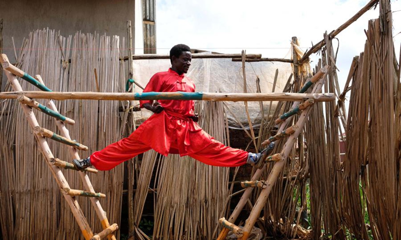 Manisuru Ssejjemba stretches during his Chinese martial arts training at a makeshift training center behind his house in Katooke, north of Uganda's capital Kampala, Aug. 17, 2021.(Photo: Xinhua)