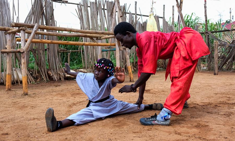 Manisuru Ssejjemba (R) instructs as his daughter Hasifa Nakirijja practices Chinese martial arts at a makeshift training center behind their house in Katooke, north of Uganda's capital Kampala, Aug. 17, 2021.(Photo: Xinhua)