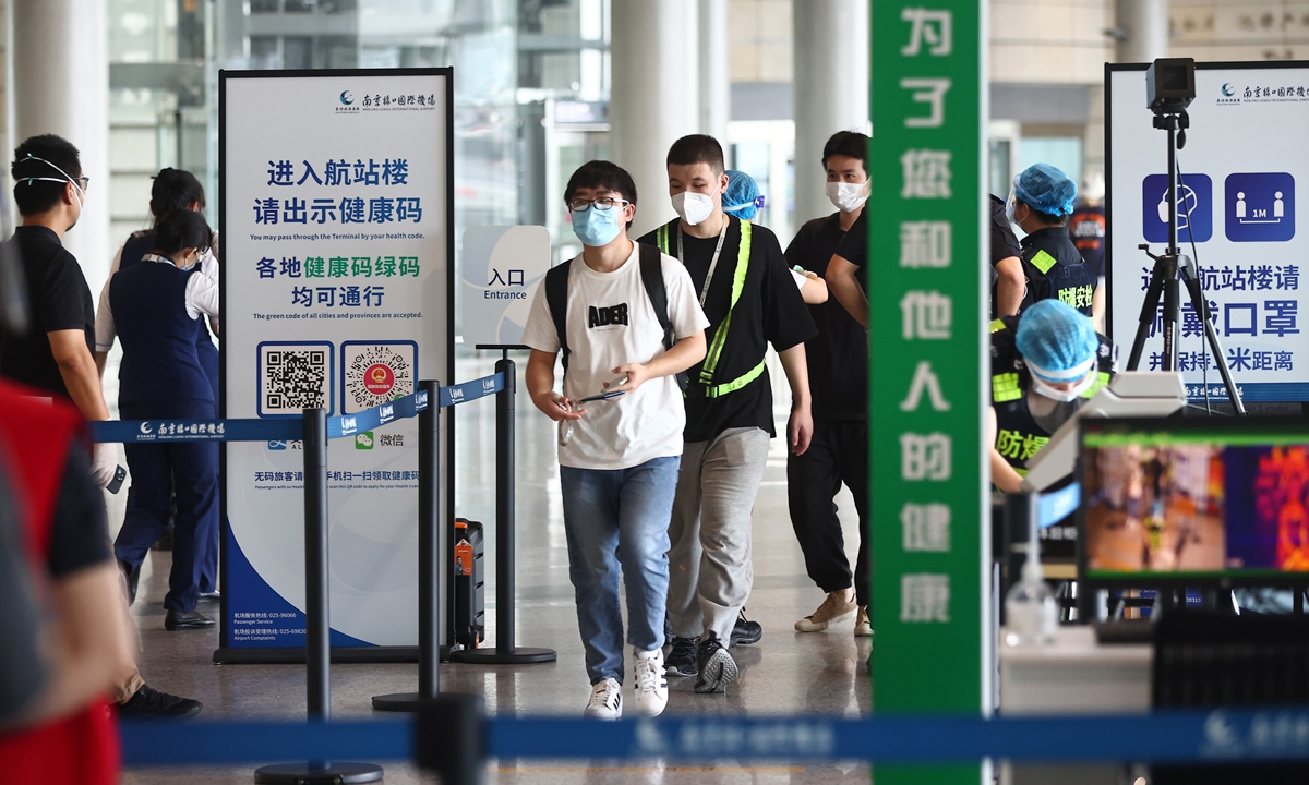 Passengers show their health codes and have their temperatures checked before entering terminals at Nanjing Lukou International Airport on Thursday, the day domestic flights were resumed after suspension due to a COVID-19 resurgence that started on July 20. The outbreak that involved hundreds in at least 27 cities is the most extensive since Wuhan outbreak last year, National Health Commission officials said. Photo: VCG