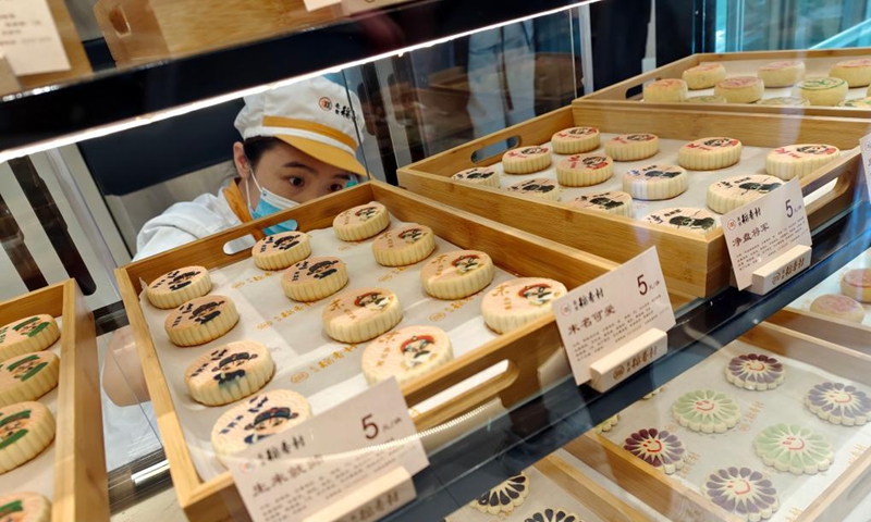 A staff member of Daoxiangcun arranges Chinese pastries in Beijing, capital of China, Aug. 25, 2021.Photo: Xinhua
